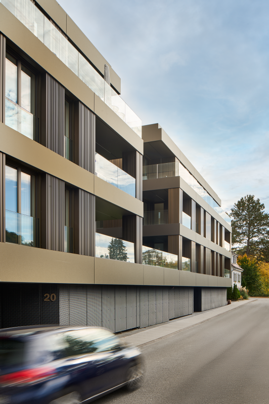 Moderne Wohnanlage in Nagold mit Fassade aus vertikalen Metalllamellen und großzügigen Balkonen entlang der Straße.  geplant und umgesetzt von arc+ Freudenstadt