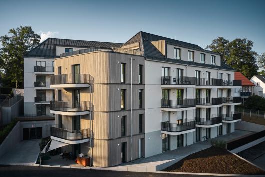 Wohnanlage in Freudenstadt mit Balkonen, teilweise Holzfassade und klar gegliederten Baukörpern um einen Innenhof geplant von arc+