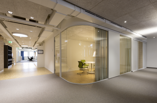 Verglaster Besprechungsraum mit geschwungener Glasfassade, flexibler Vorhanglösung und offener Bürostruktur im Büro am Vorstadtplatz für Häfele, internationaler Hersteller von Möbel- und Baubeschlägen, Schließsystemen und Beleuchtung, in Nagold. Bauherr: Häfele SE & Co KG. Geplant und umgesetzt von arc+ GmbH Freudenstadt.