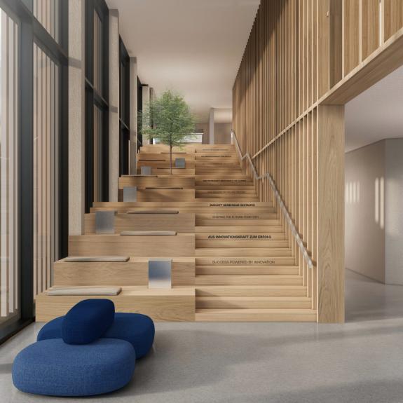 Innenraum des HOMAG Neubaus mit großzügiger Holztreppe als Sitz- und Begegnungszone im Foyer – geplant von arcplus mit dominierender Holzgestaltung und integrierter Markenbotschaft- geplant von arc+ Freudenstadt