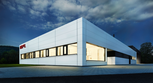 Neubau für MEDEL Medizintechnik, geplant und umgesetzt von arcplus. Das Gebäude erfüllt höchste Anforderungen an Präzision, Sauberkeit und Arbeitsumgebung für die Produktion von Mikroelementen zur Implantologie im Mikromaßstab