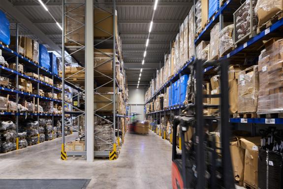 Modernes Palettenlager mit Hochregalen, Gabelstaplerverkehr und optimierten Materialflüssen im Logistik- und Verwaltungsgebäude der SHW Logistik und Vertrieb GmbH, Hersteller von Schmiedeprodukten, Handwerkzeugen sowie Lösungen für Garten-, Forst-, Landwirtschafts- und Kommunaltechnik, in Freudenstadt. Bauherr: SHW Logistik und Vertrieb GmbH. Geplant und umgesetzt von arc+ GmbH Freudenstadt.