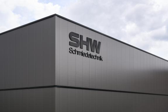 Fassadendetail des Logistik- und Verwaltungsgebäudes der SHW Logistik und Vertrieb GmbH mit Unternehmenslogo und moderner Industriearchitektur in Freudenstadt. SHW ist Hersteller von Schmiedeprodukten, Handwerkzeugen sowie Lösungen für Garten-, Forst-, Landwirtschafts- und Kommunaltechnik. Bauherr: SHW Logistik und Vertrieb GmbH. Geplant und umgesetzt von arc+ GmbH Freudenstadt.