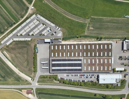 Luftaufnahme des WEINMANN Produktionsstandorts mit Gründach, Photovoltaikanlage und Holz-Hybridbau. Nachhaltige Industriearchitektur, geplant von arc+ Freudenstadt.